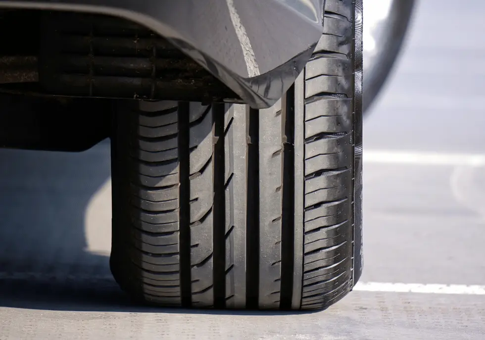 Tyre Tread Depth And Uk Law: The Complete Driver’s Guide 1 Close-up of a car's front tyre showing the tread depth and grooves used to maintain grip and channel water.
